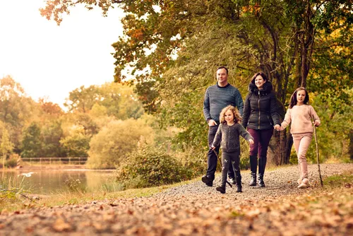 Photo of a family walking in a park near a lake
