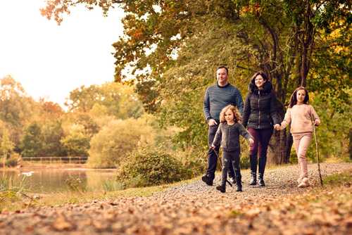 Photo of a family walking in a park near a lake